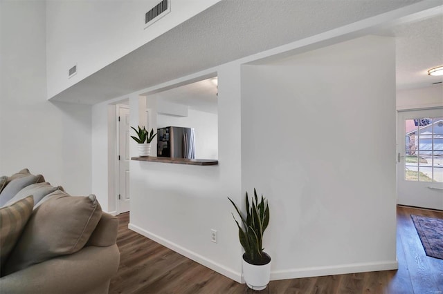 living room featuring baseboards, visible vents, and wood finished floors