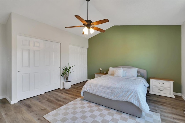 bedroom featuring lofted ceiling, a ceiling fan, baseboards, and wood finished floors