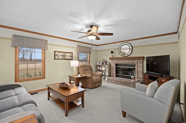 living area with visible vents, a ceiling fan, carpet flooring, crown molding, and a brick fireplace