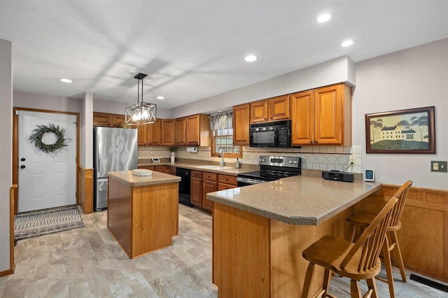 kitchen featuring black appliances, a sink, a center island, a peninsula, and brown cabinetry