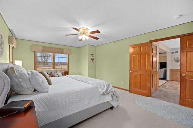 bedroom with a textured ceiling, carpet flooring, visible vents, and ceiling fan