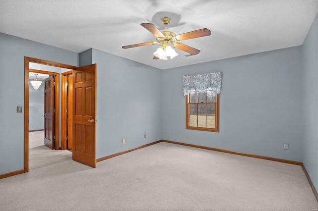 spare room featuring carpet flooring, a ceiling fan, and baseboards