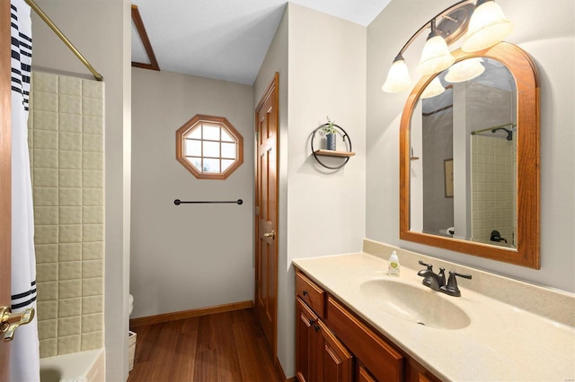 full bath with baseboards, toilet, shower / bath combo with shower curtain, wood finished floors, and vanity