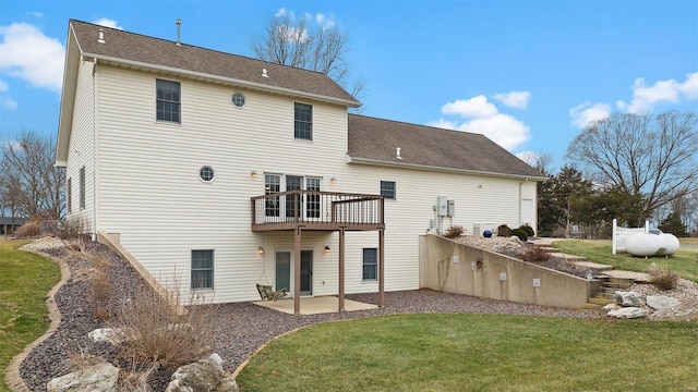 back of house featuring a yard, a patio area, roof with shingles, and a wooden deck