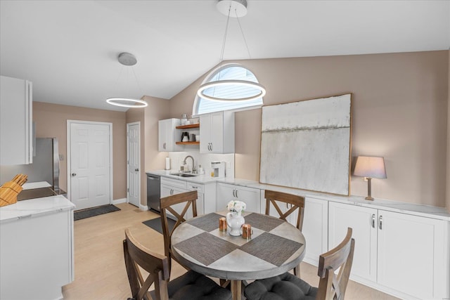 dining room with lofted ceiling and light wood finished floors