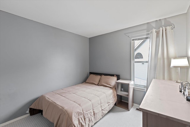 bedroom with light carpet, visible vents, baseboards, and multiple windows