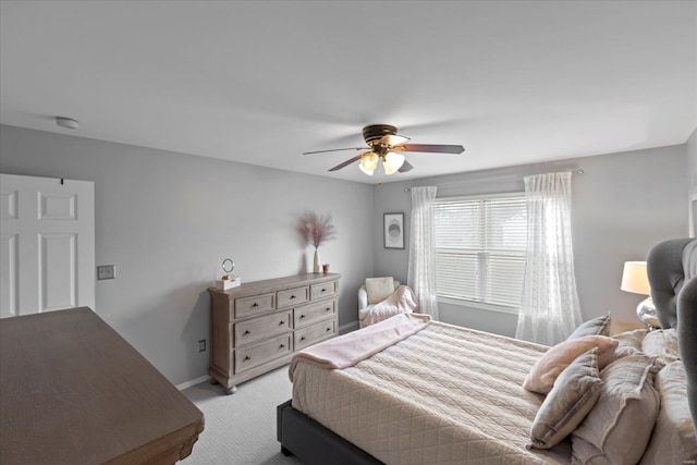 bedroom with light carpet, baseboards, and a ceiling fan