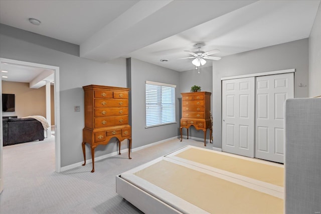 carpeted bedroom featuring a ceiling fan, a closet, and baseboards