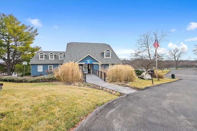 view of front of property with decorative driveway and a front lawn