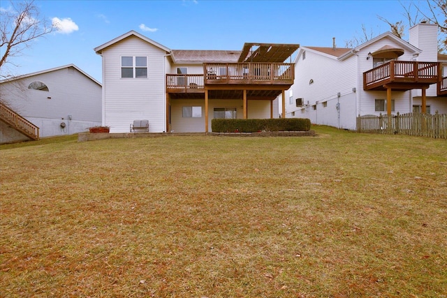 back of property featuring fence, a deck, and a lawn