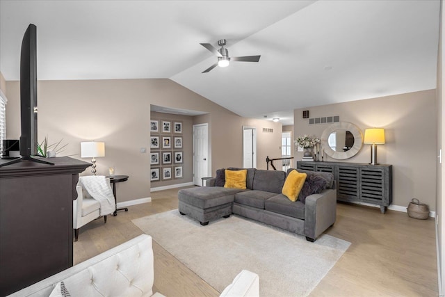 living room featuring light wood finished floors, lofted ceiling, visible vents, ceiling fan, and baseboards