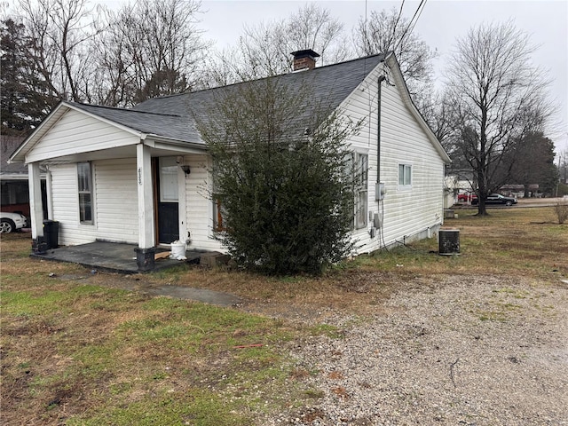 view of front of property with a front lawn, a patio area, and central air condition unit