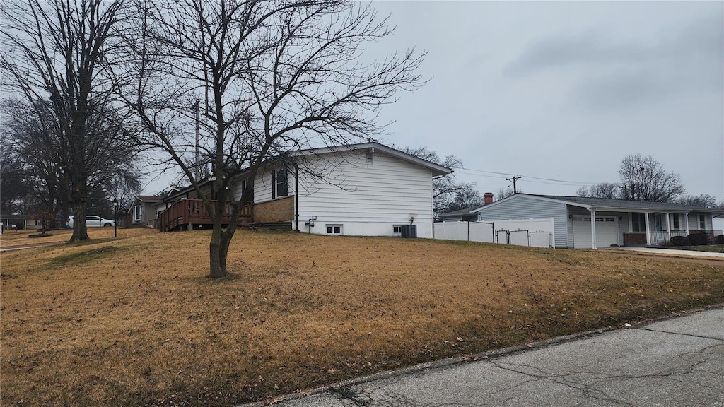 view of home's exterior featuring a garage, a lawn, and central air condition unit