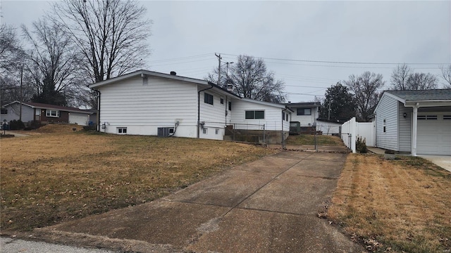 view of side of home featuring a garage, a yard, and central air condition unit