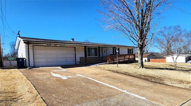 ranch-style home with a garage, fence, and concrete driveway