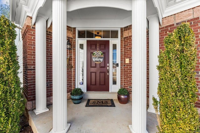 entrance to property featuring brick siding and a porch