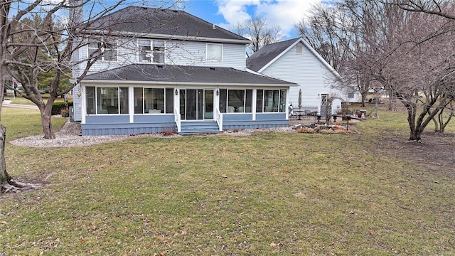 back of property featuring a sunroom, a shingled roof, and a yard