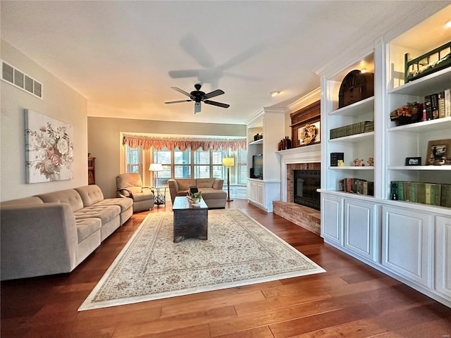 living room featuring ceiling fan, a fireplace, visible vents, and dark wood finished floors