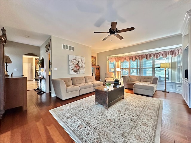 living room with a ceiling fan, visible vents, and wood finished floors