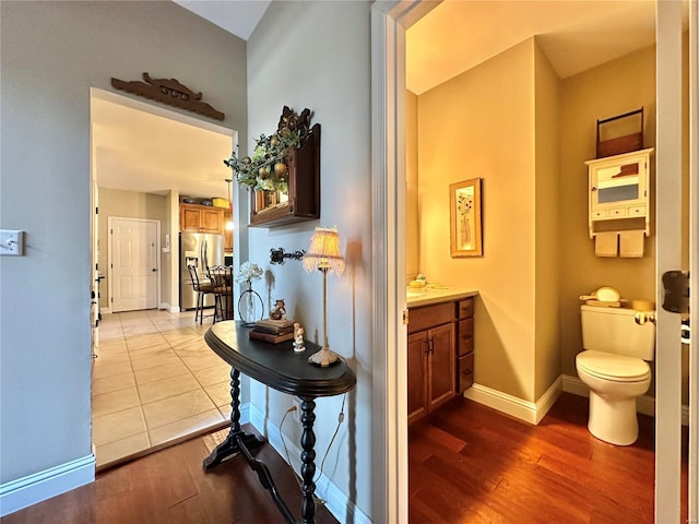 hallway featuring wood finished floors and baseboards