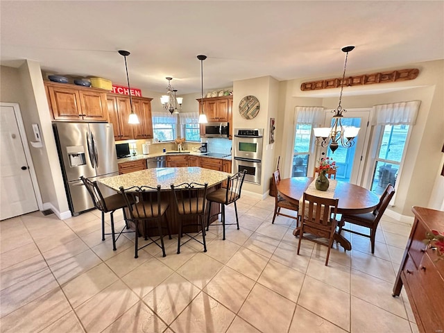 dining space with baseboards, a chandelier, and light tile patterned flooring