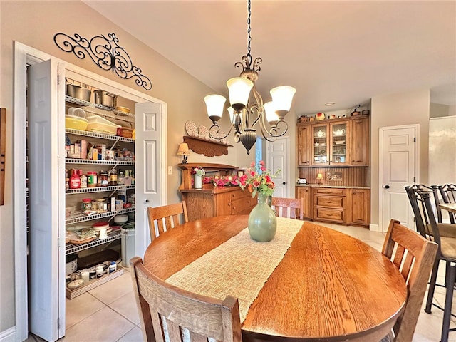 dining space with light tile patterned flooring and an inviting chandelier