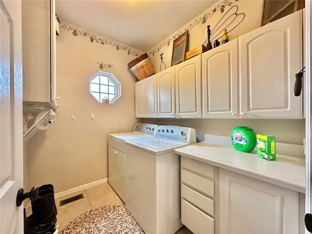 laundry area with light tile patterned floors, cabinet space, visible vents, washer and dryer, and baseboards