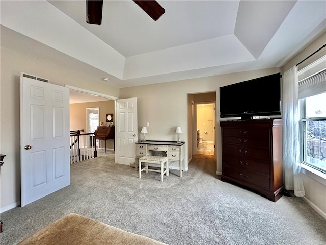 interior space featuring light carpet, baseboards, a raised ceiling, and a ceiling fan