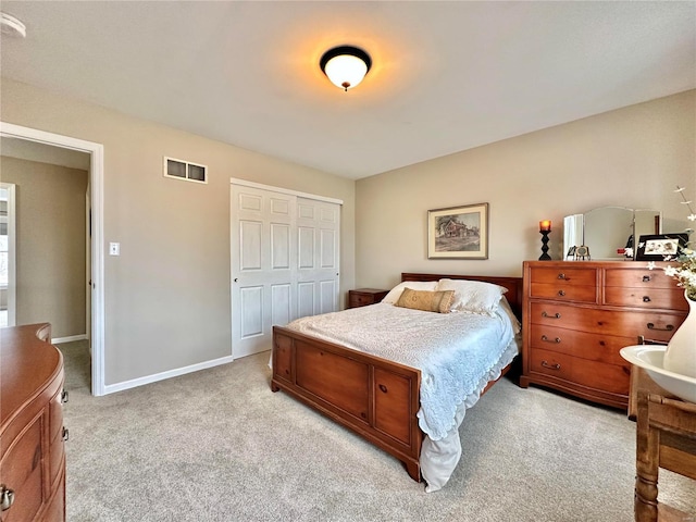 bedroom with light carpet, a closet, visible vents, and baseboards