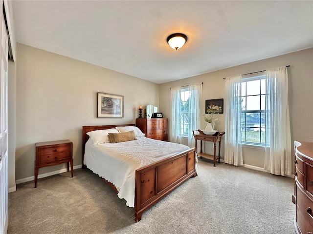 bedroom featuring light colored carpet and baseboards