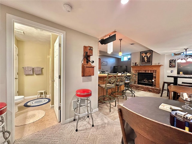 carpeted dining space featuring a bar, tile patterned flooring, visible vents, and baseboards