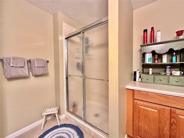 full bathroom featuring a stall shower, tile patterned flooring, and baseboards