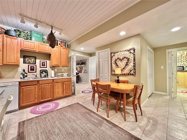 kitchen featuring recessed lighting, light countertops, a sink, dishwasher, and baseboards