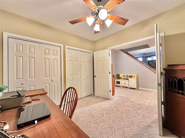 office area with light carpet, ceiling fan, and baseboards