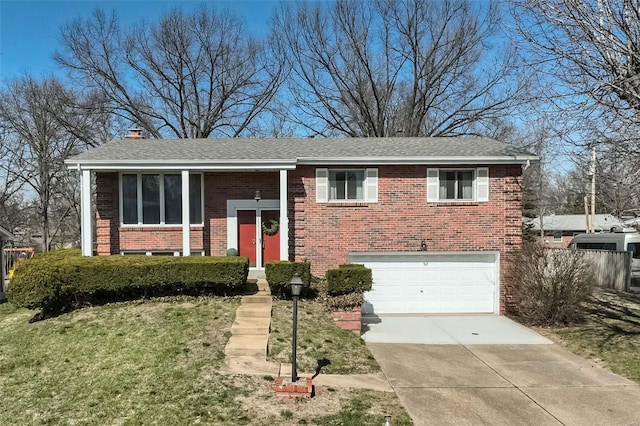 raised ranch featuring driveway, roof with shingles, an attached garage, a front lawn, and brick siding