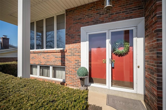 doorway to property with brick siding