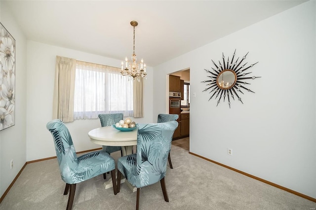 dining space with baseboards, light carpet, and a notable chandelier