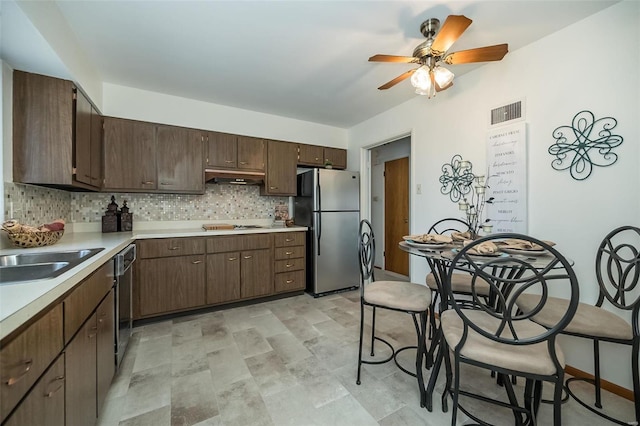 kitchen with visible vents, under cabinet range hood, backsplash, stainless steel appliances, and light countertops