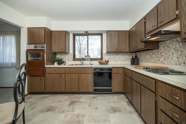 kitchen featuring a sink, oven, stainless steel electric stovetop, black dishwasher, and under cabinet range hood