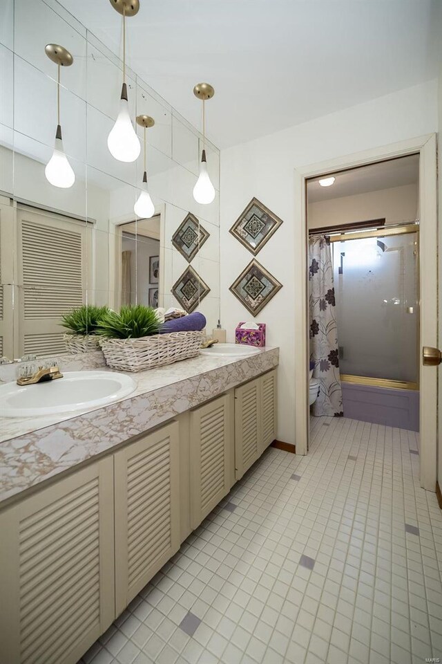 bathroom featuring double vanity, toilet, shower / bath combo, and a sink