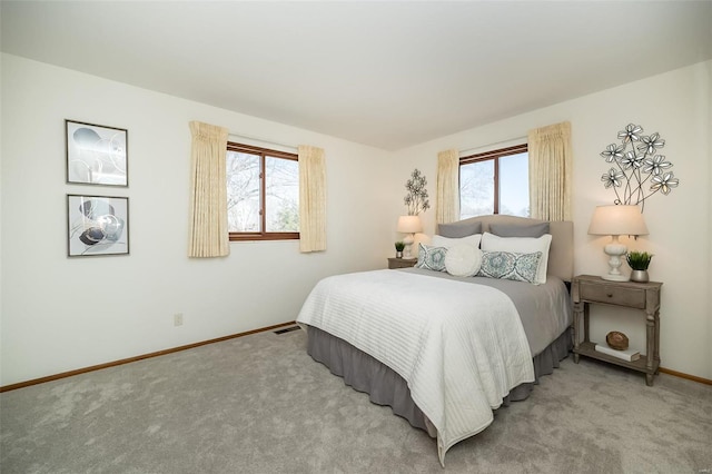 bedroom featuring baseboards, multiple windows, light carpet, and visible vents