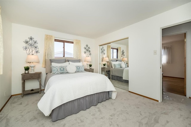 carpeted bedroom with a closet and baseboards