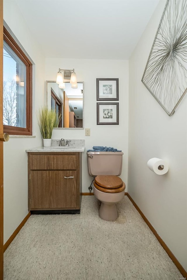 bathroom featuring vanity, toilet, and baseboards