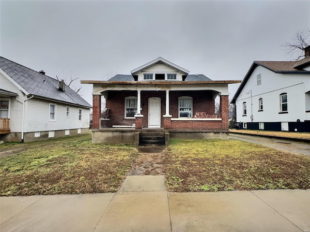 bungalow-style home featuring a porch and a front yard