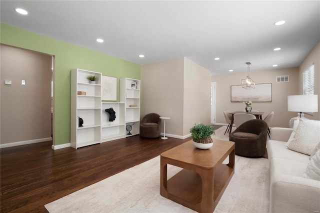 living area with baseboards, visible vents, dark wood-type flooring, and recessed lighting