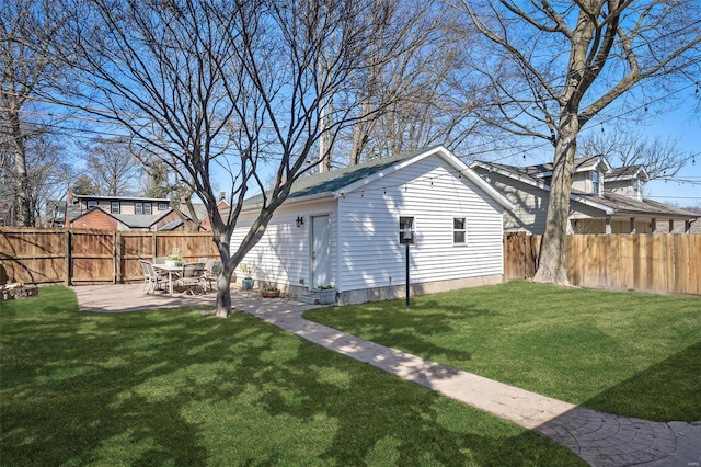 view of yard with an outbuilding, a fenced backyard, and a patio area