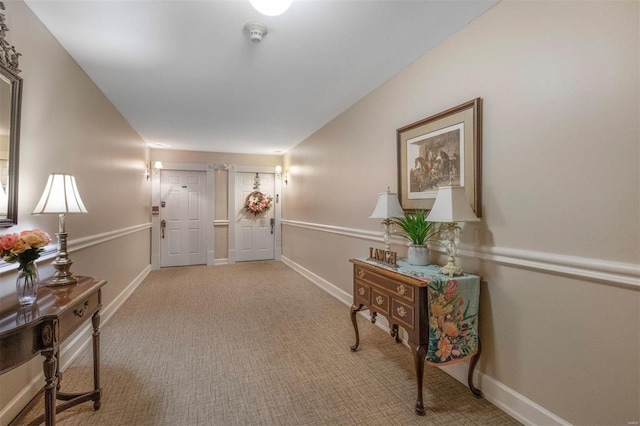 interior space featuring light carpet and baseboards