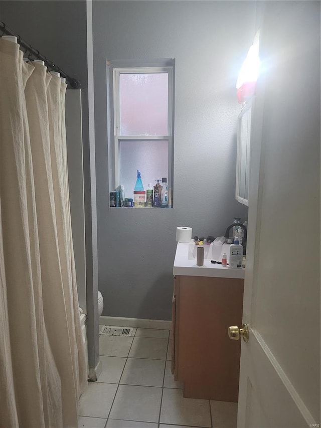 bathroom with vanity, toilet, and tile patterned flooring