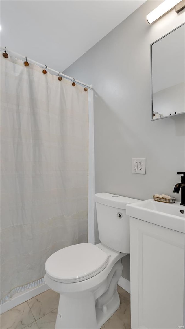 bathroom featuring toilet, marble finish floor, a shower with shower curtain, and vanity