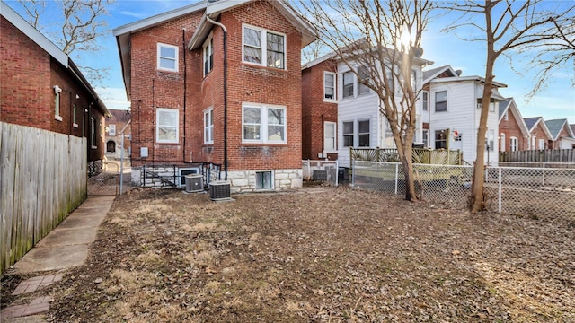 back of property featuring brick siding, a fenced backyard, and central air condition unit